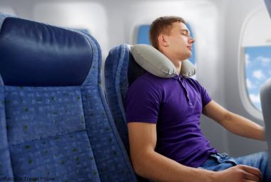 Young man with an inflatable travel pillow on an airplane